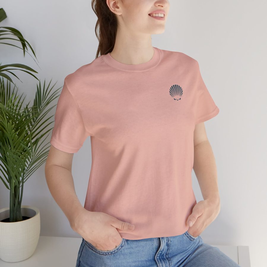 Woman wearing the Gone Shelling tee in soft peach, with a small Shellwake logo on the chest