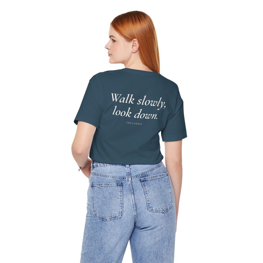 Back of the tee with the phrase Walk slowly, look down.